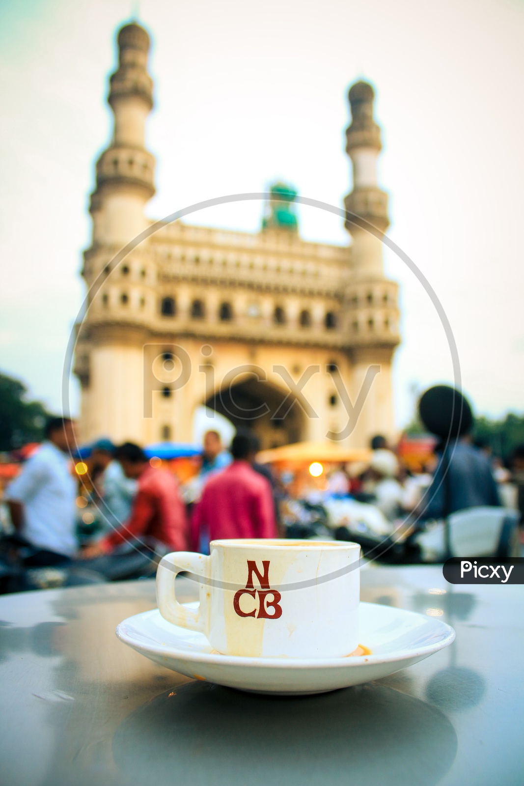 Tea cup and a saucer on the table with Charminar in background
