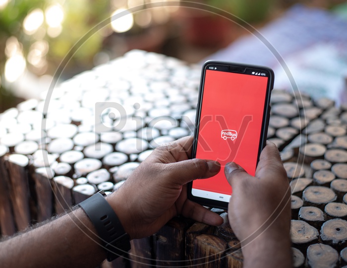 Indian Man Accessing Red Bus App For Boooking Bus Tickets Online in smart Phone
