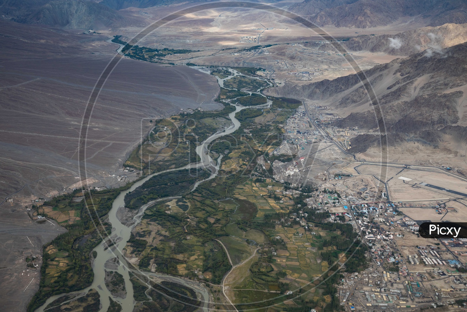 Aerial view of Indus river alongside the crops and city buildings