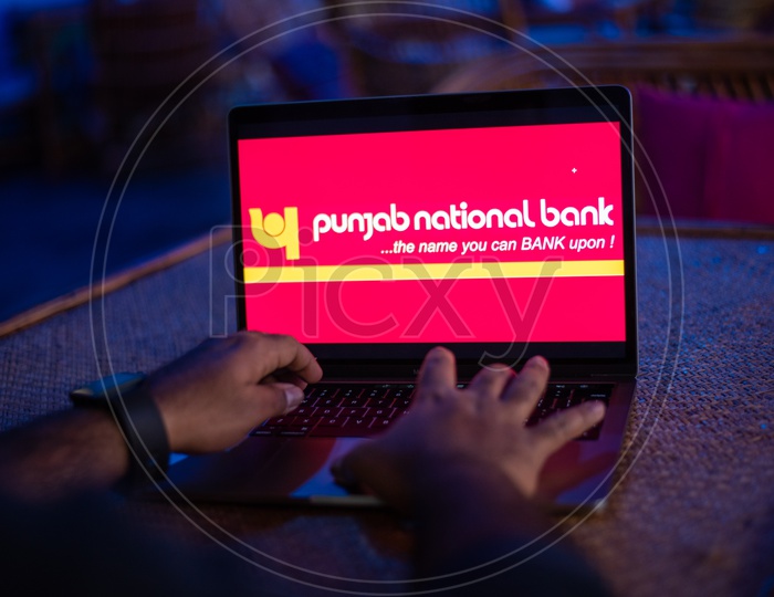 Indian man Accessing Punjab National Bank Online Portal In  Laptop