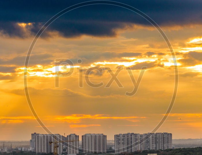 High Rise Apartments and Construction Buildings With Golden Sun Rays Falling Over Them