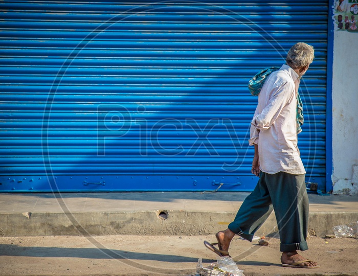 Old man walking by the street