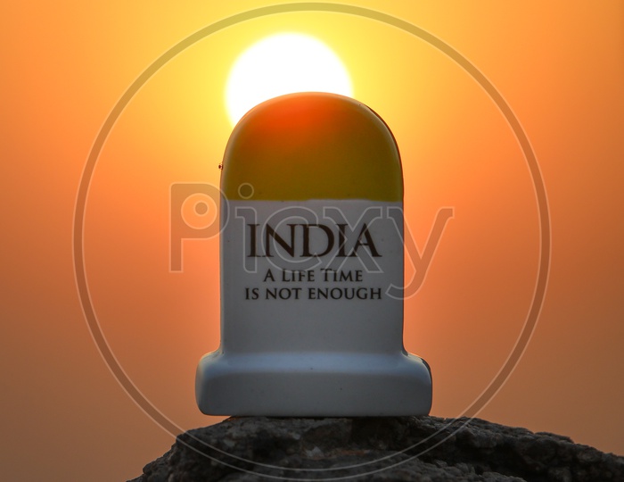 Miniature Mile Stone Of INDIA A Life Time Is Not Enough Tag Line  With a Sunset Background