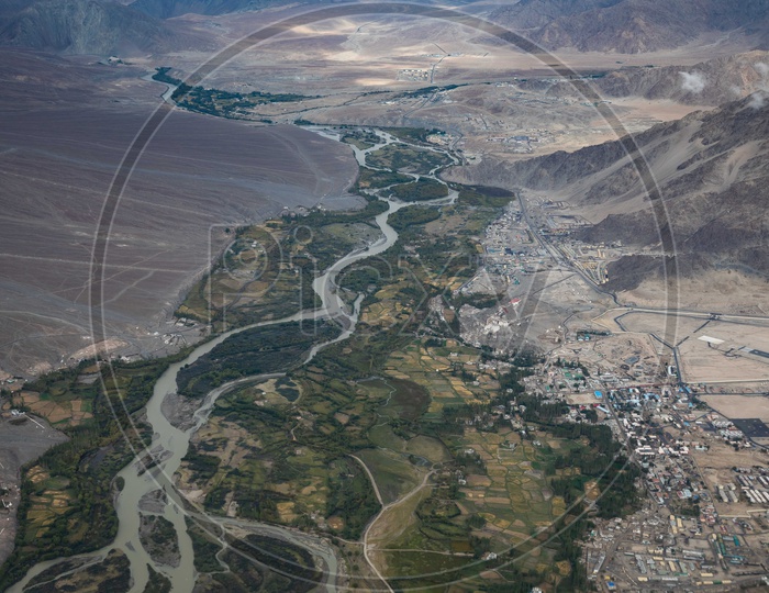 Aerial view of Indus river alongside the crops and city buildings