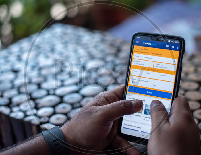 Indian man Using Booking.com App For Flight Ticket  Booking  in Smart Phone