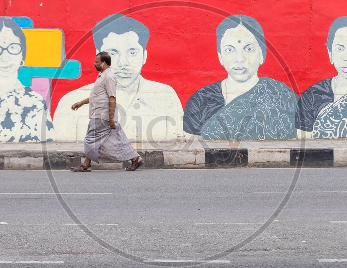 A Man Walking Along The Necklace Road With Abstract Art or Wall Arts or Graffiti  on Road Side Walls