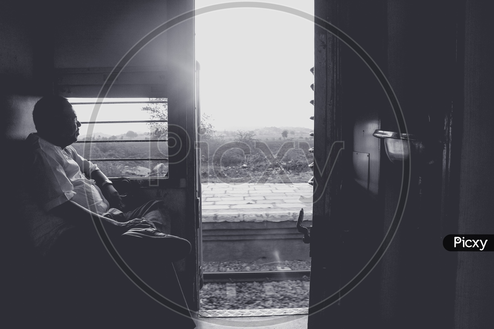 Monochrome of a man Sitting at a Train door
