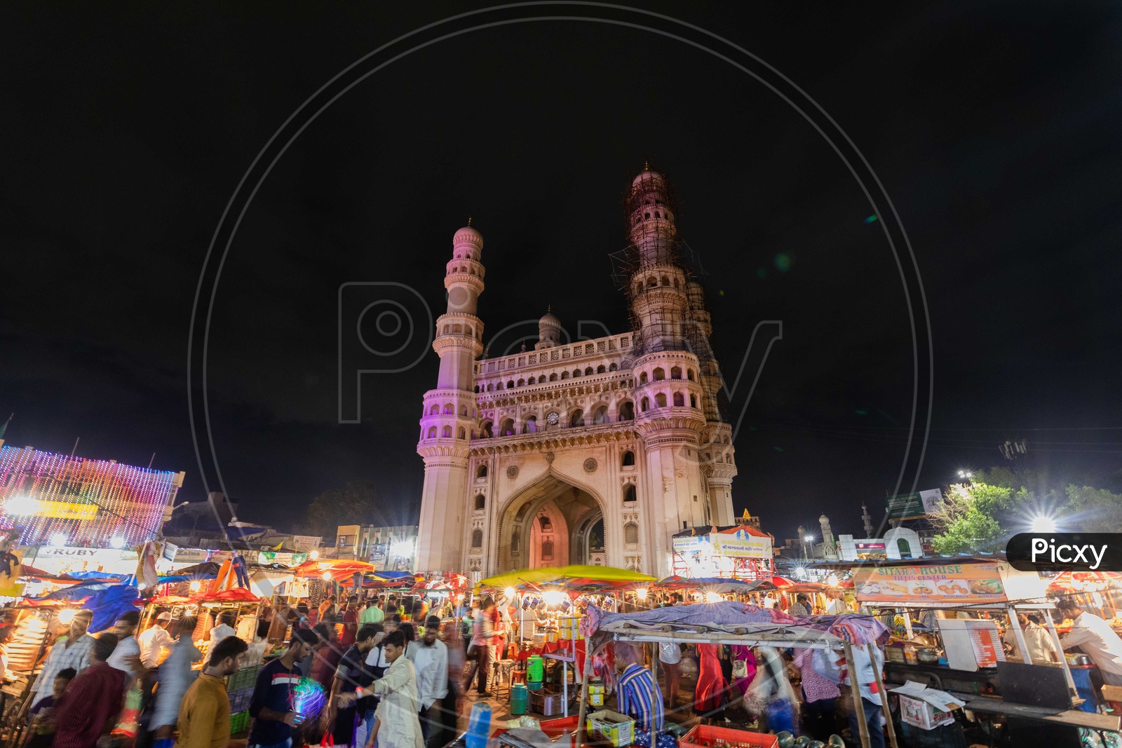 Bazaar street crowd alongside the Charminar during the night