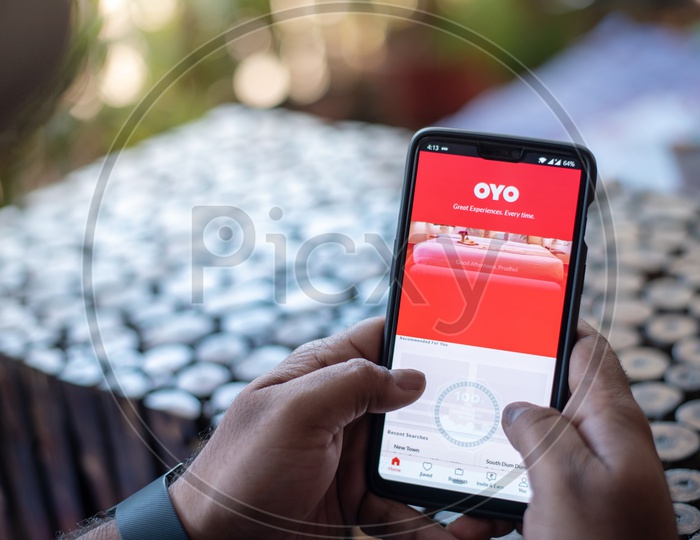 Indian Man Using OYO App for Hotels Booking in Smart Phone