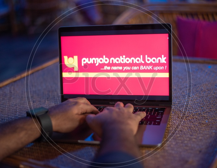 Indian Man Accessing Punjab National Bank Online Portal In Laptop