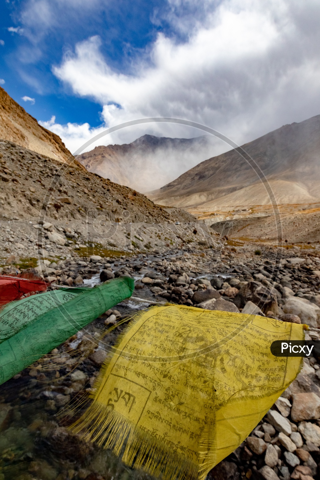 Waving prayer flags alongside the mountains covered with mist and clouds