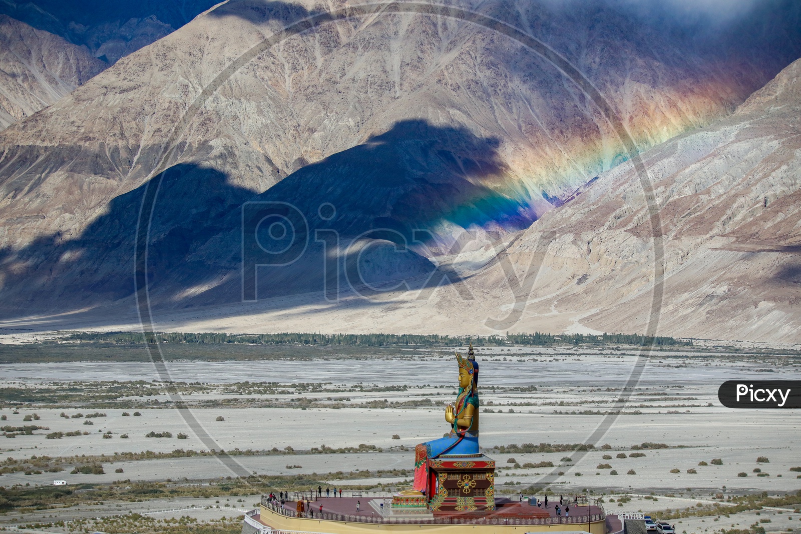 Landscape of rainbow over the hills alongside Big Maitreya Buddha statue at Diskit Monastery, Nubra valley