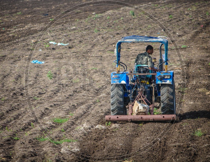 Farmer Ploughing Agricultural Land With His Tractor