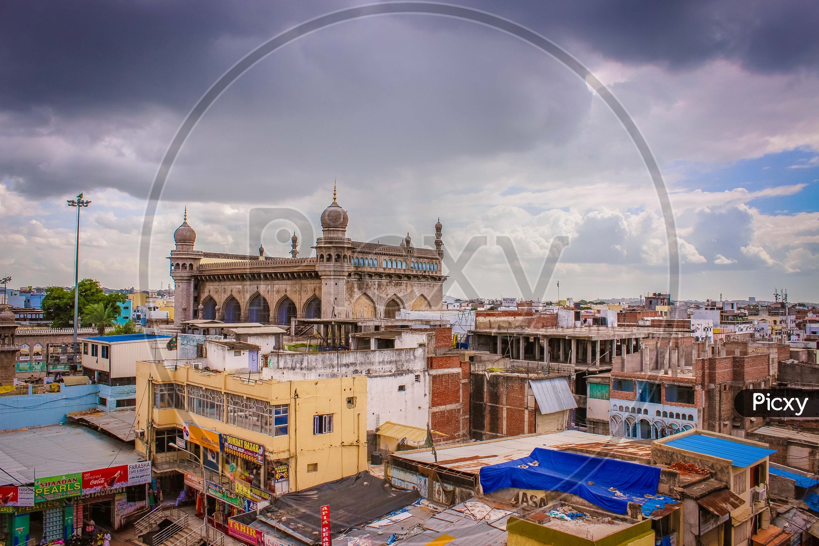 Landscape of Mecca Masjid during daylight covered with dark clouds