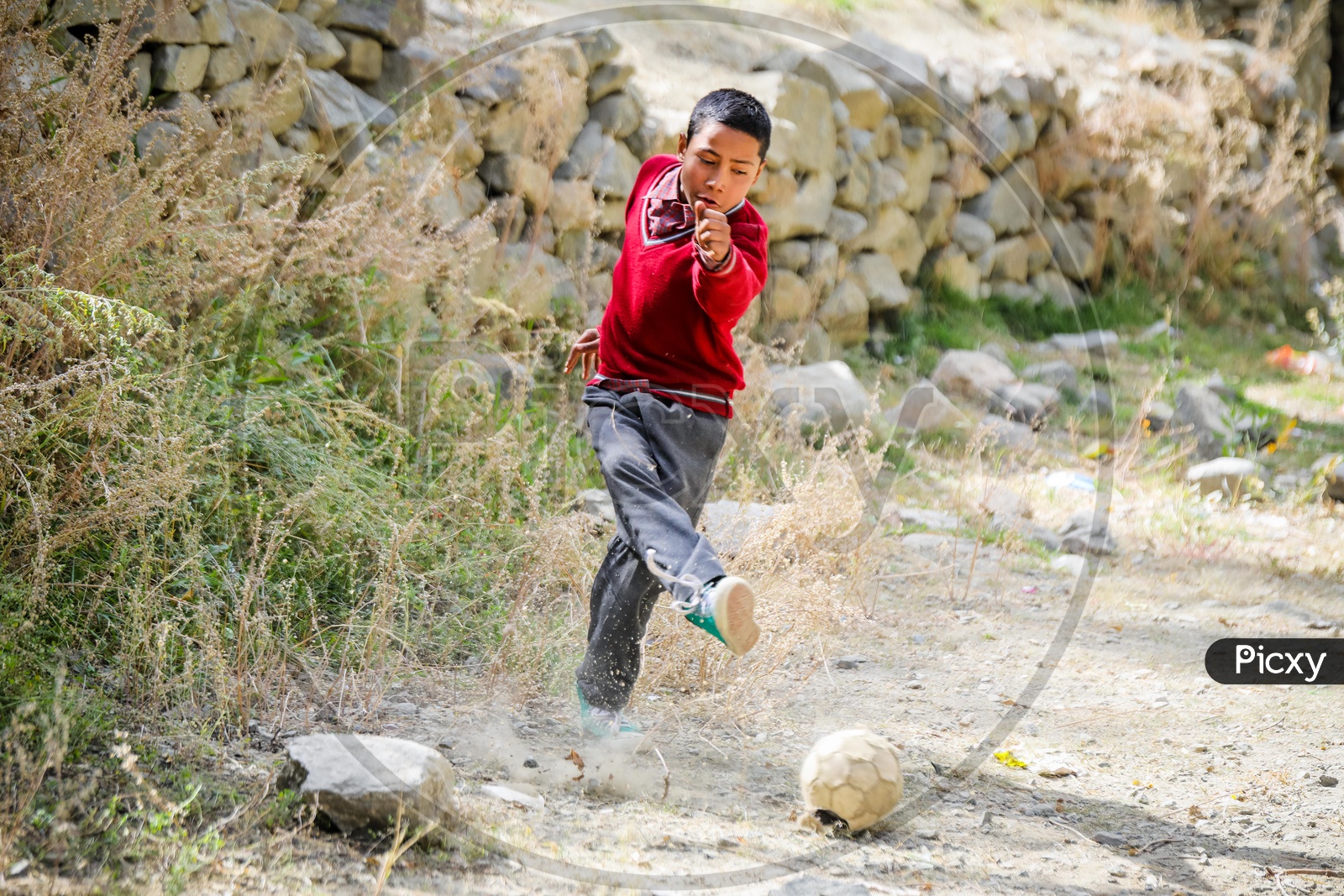 A Himalayan kid playing football