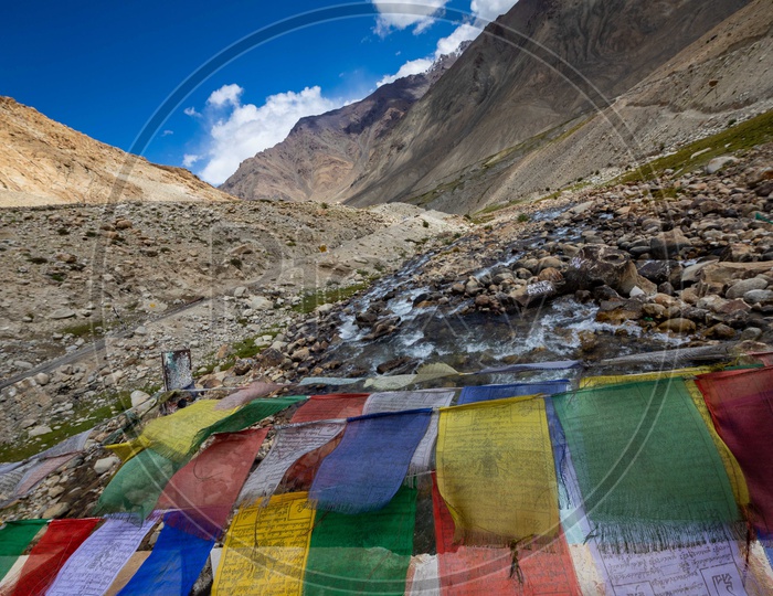 Prayer flags alongside the mountains by the rocks