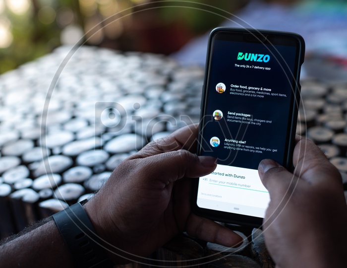 Indian Man using Dunzo app  in Smart Phone