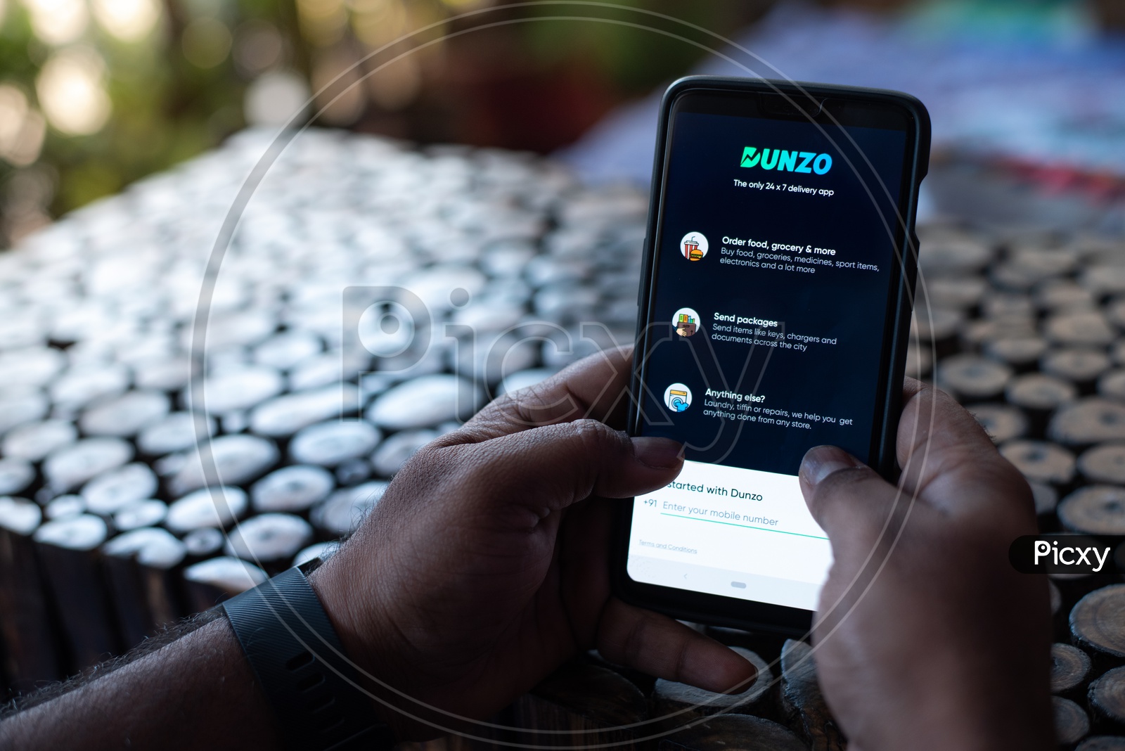 Indian Man using Dunzo app  in Smart Phone