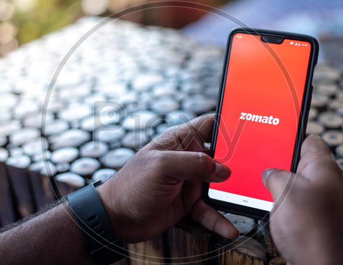 Indian Man using Zomato App for online food delivery in Smart Phone