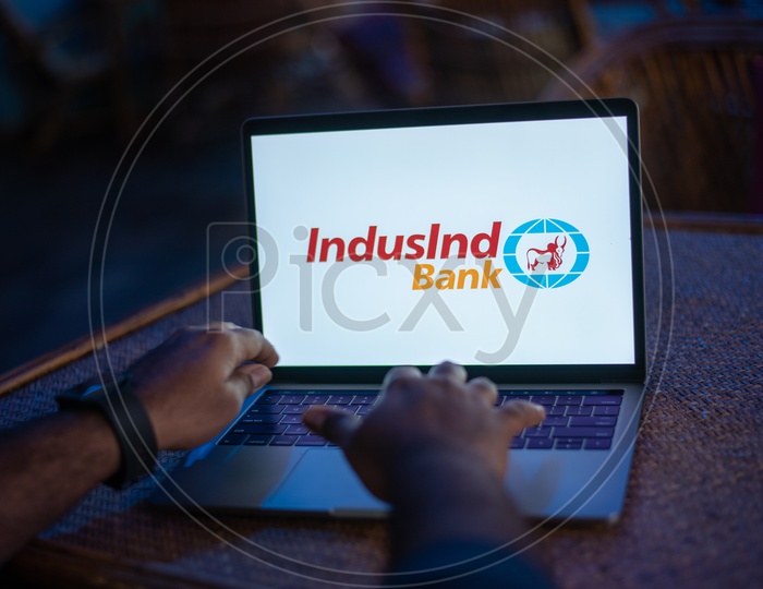 Indian Youth Accessing Online Banking Of IndusInd  BANK  in Laptop