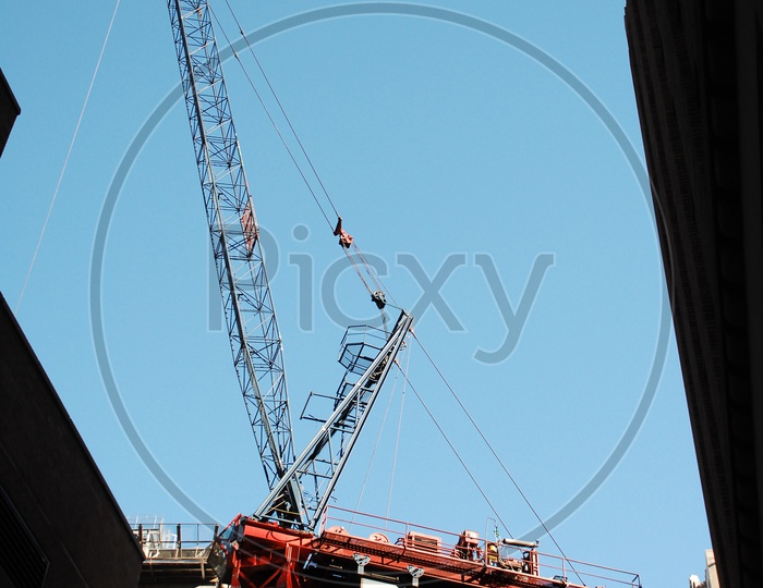 Tower crane alongside the High Rise Buildings with blue sky in background