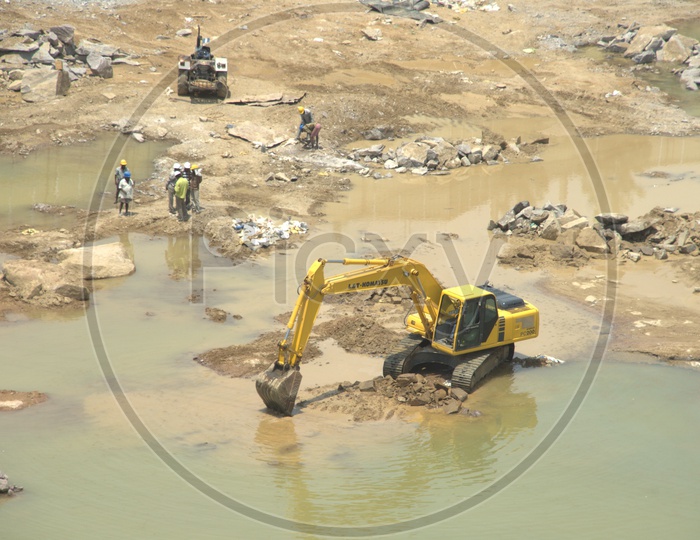 Bulldozer and group of labourers working alongside the excavation site