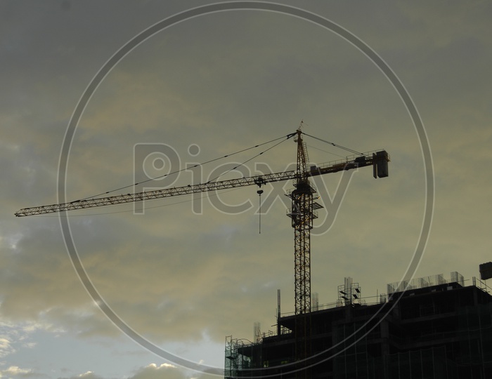 Tower crane alongside the construction of hi rise buildings with cloudy sky