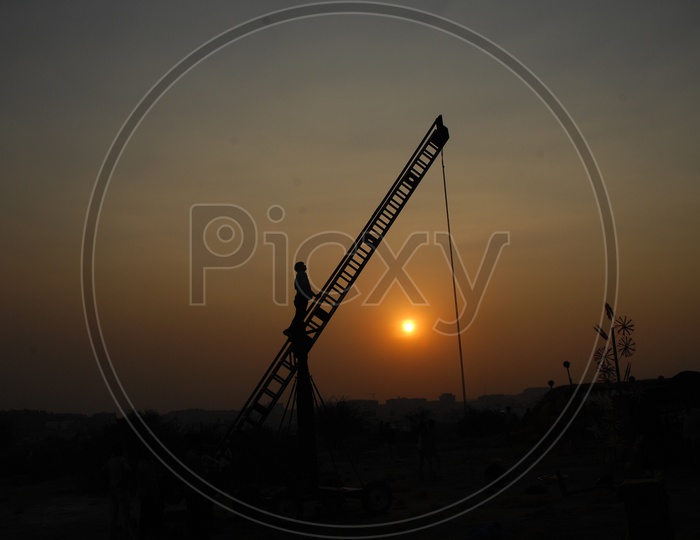 Silhouette of a man on the crane during sunset