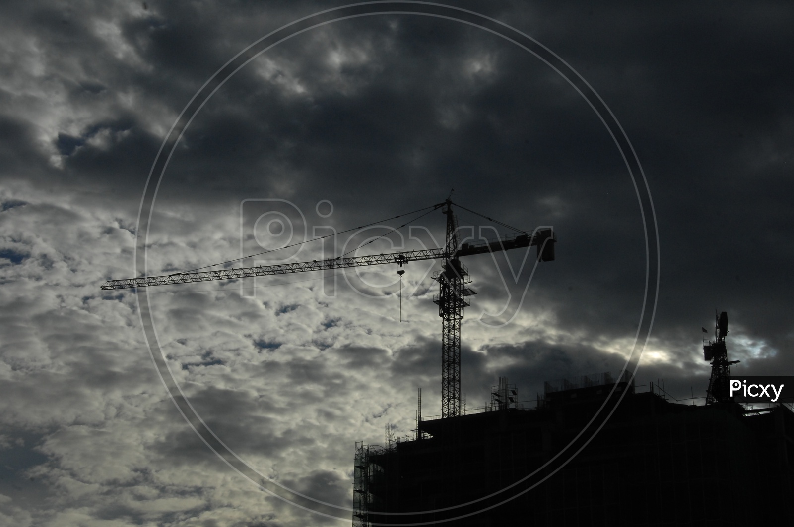 Tower Crane at the construction of a building with cloudy sky