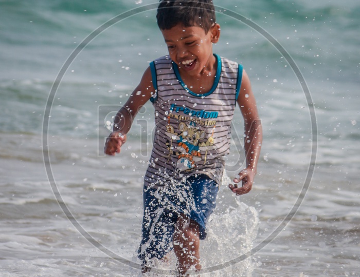 Little Boy Playing in the Beach water