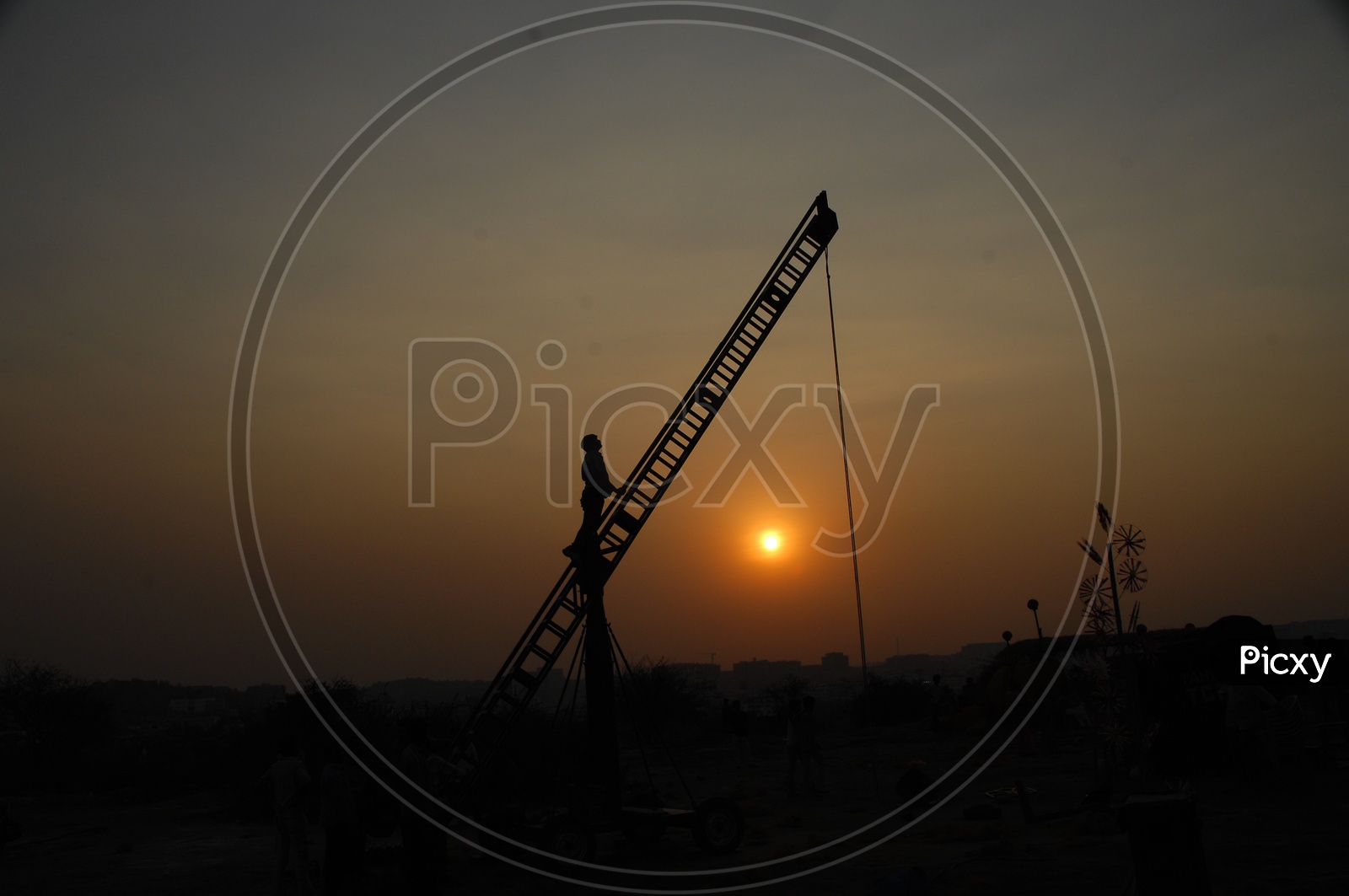 Silhouette of a man on the crane during sunset