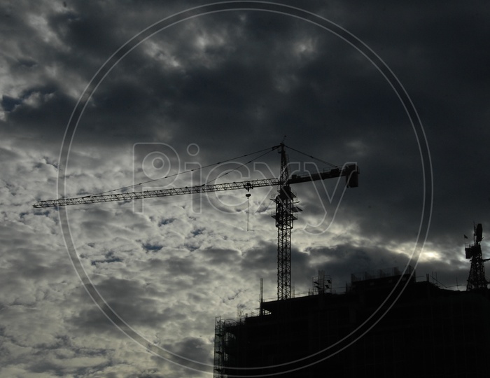 Tower Crane at the construction of a building with cloudy sky
