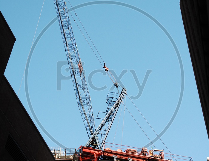 Tower crane alongside the High Rise Buildings with blue sky in background