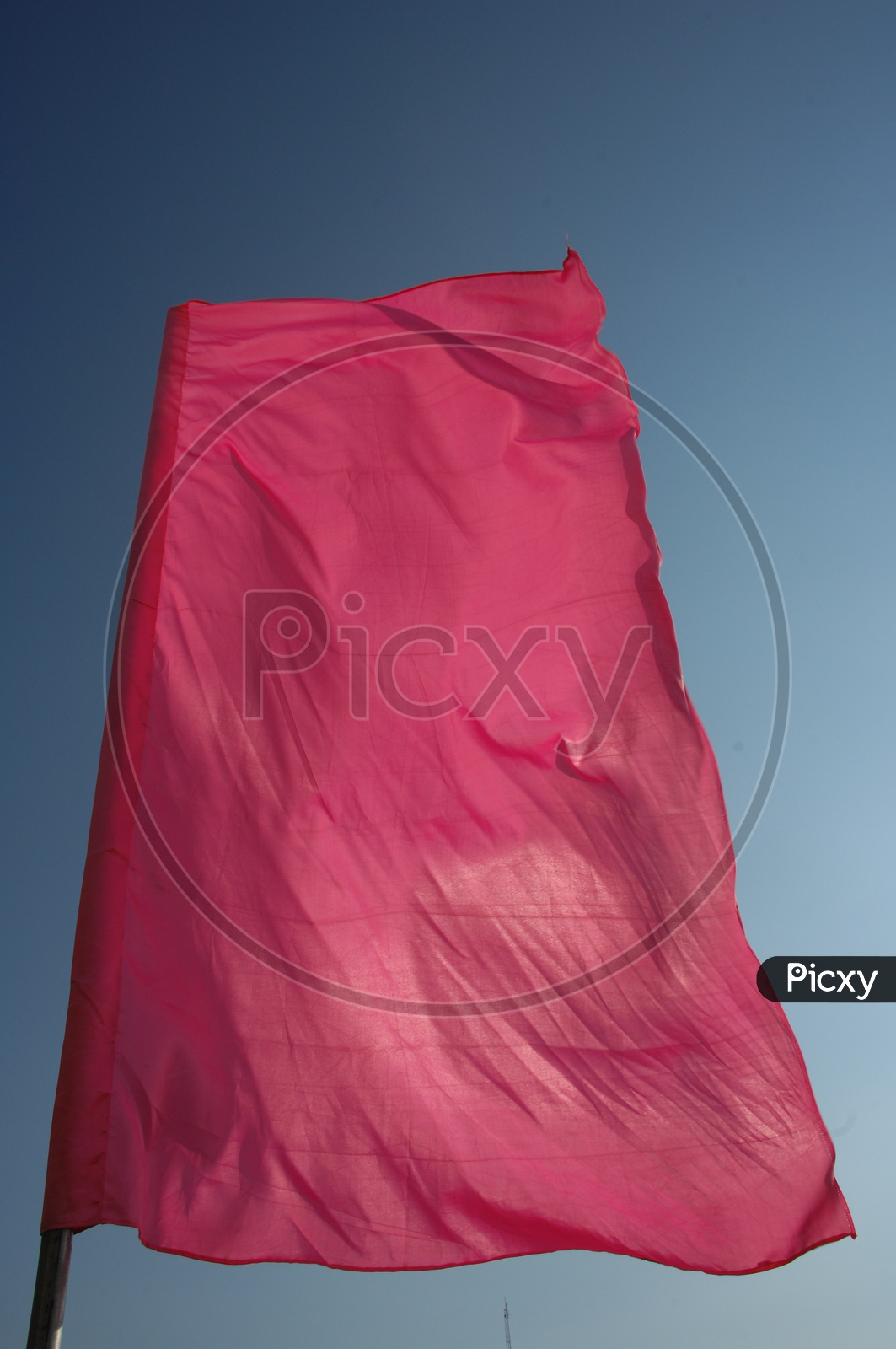 Pink curtain flag waving in the daylight with blue sky