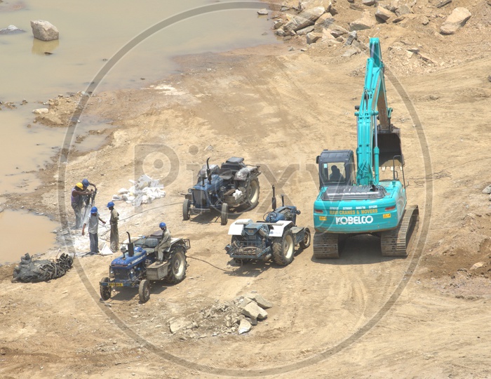 Bulldozer and group of labourers working alongside the tractors at a construction site
