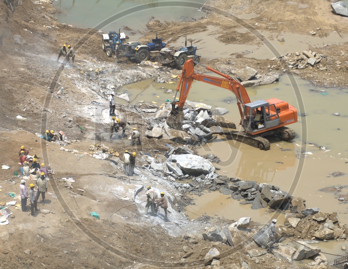 Labourers working alongside the bulldozer in the excavation site