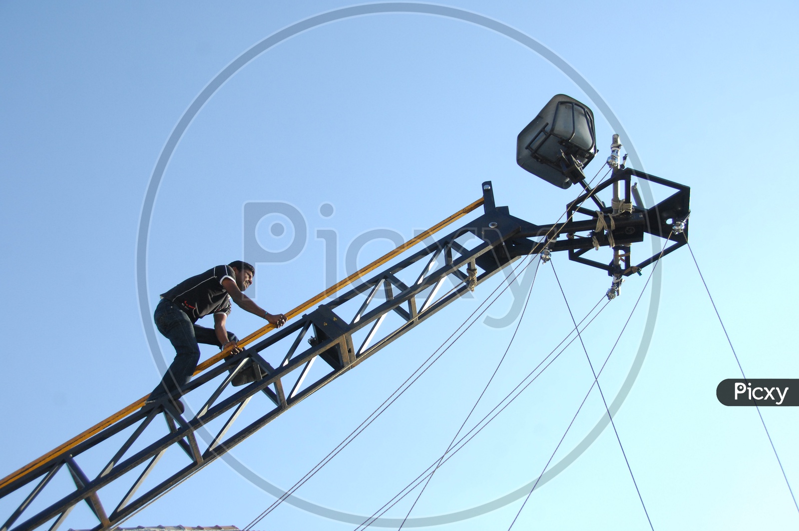 Image of Man crawling along the crane tower to take the seat-EZ930394-Picxy