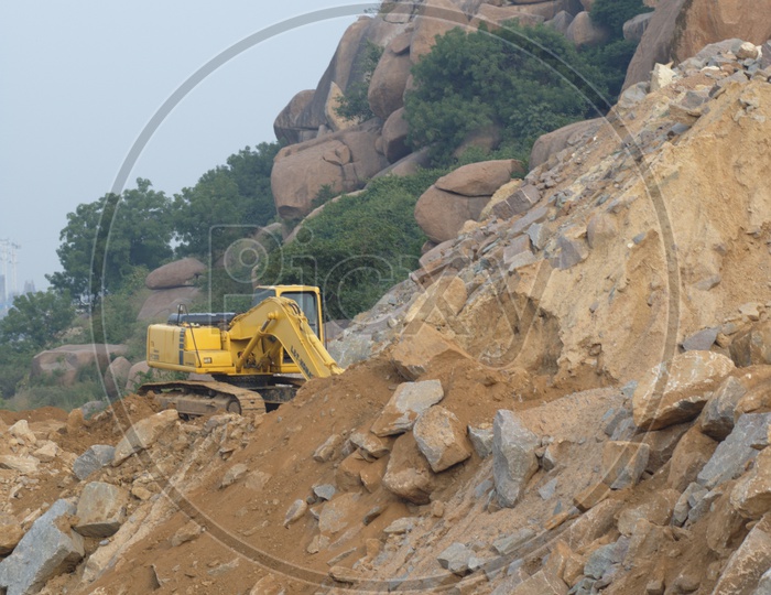 Bulldozer quarrying the construction rocks alongside the hill