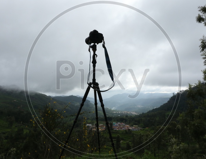 A DSLR Camera Mounted to a Tripod on a hill Top