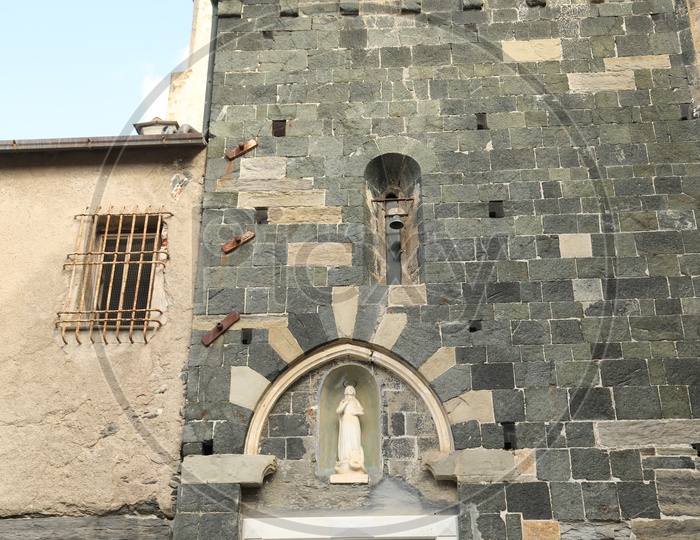 Sculpture and ancient bell on the wall