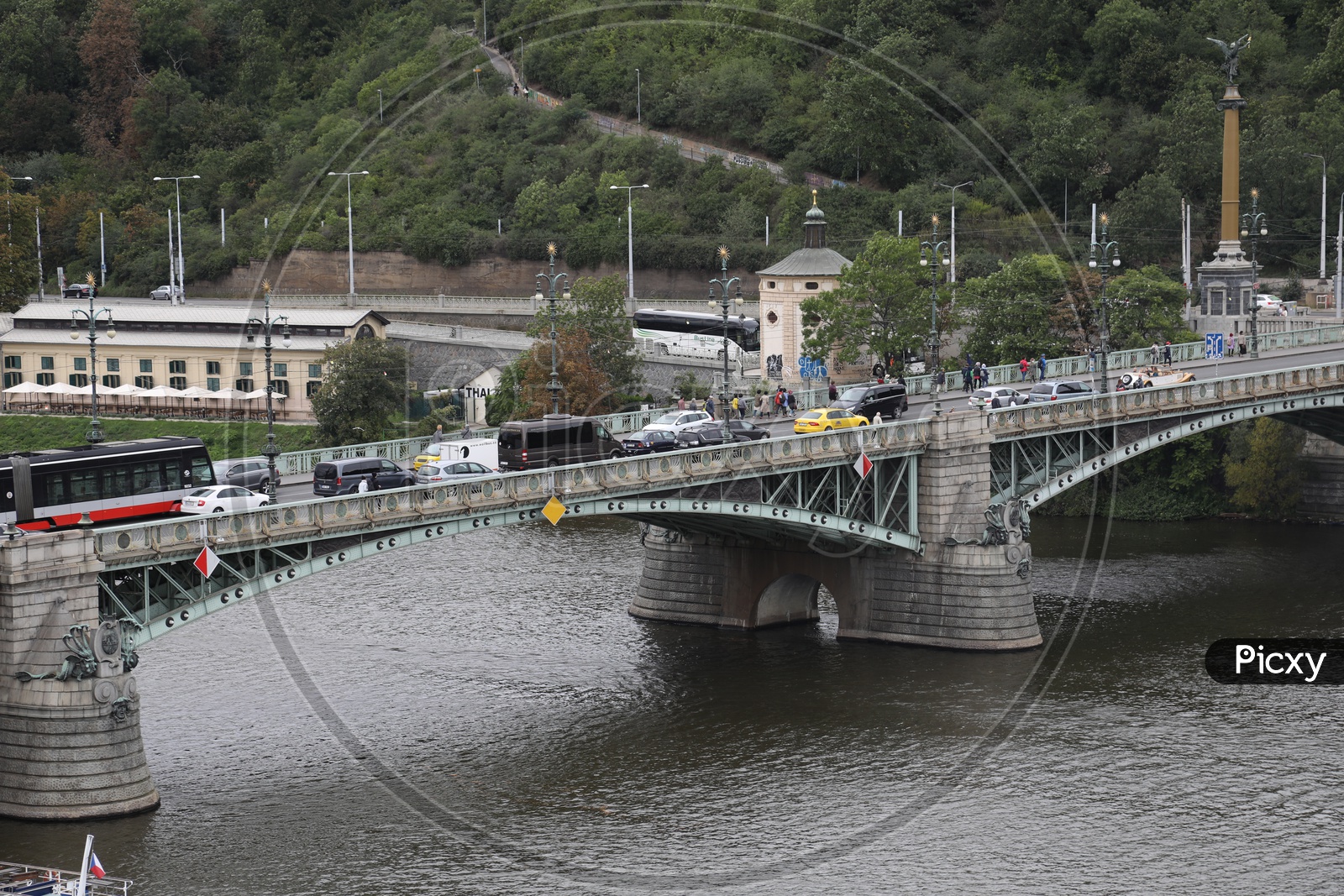 vehicles move on the bridge which is above the river