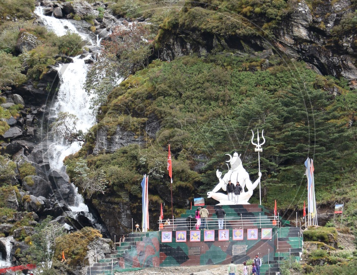 Waterfall with lord shiva idol beside
