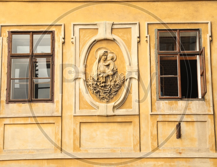 Mary sculpture on a wall alongside the windows