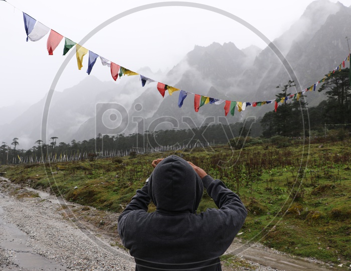 A tourist taking a photo of the mountains in Sikkim