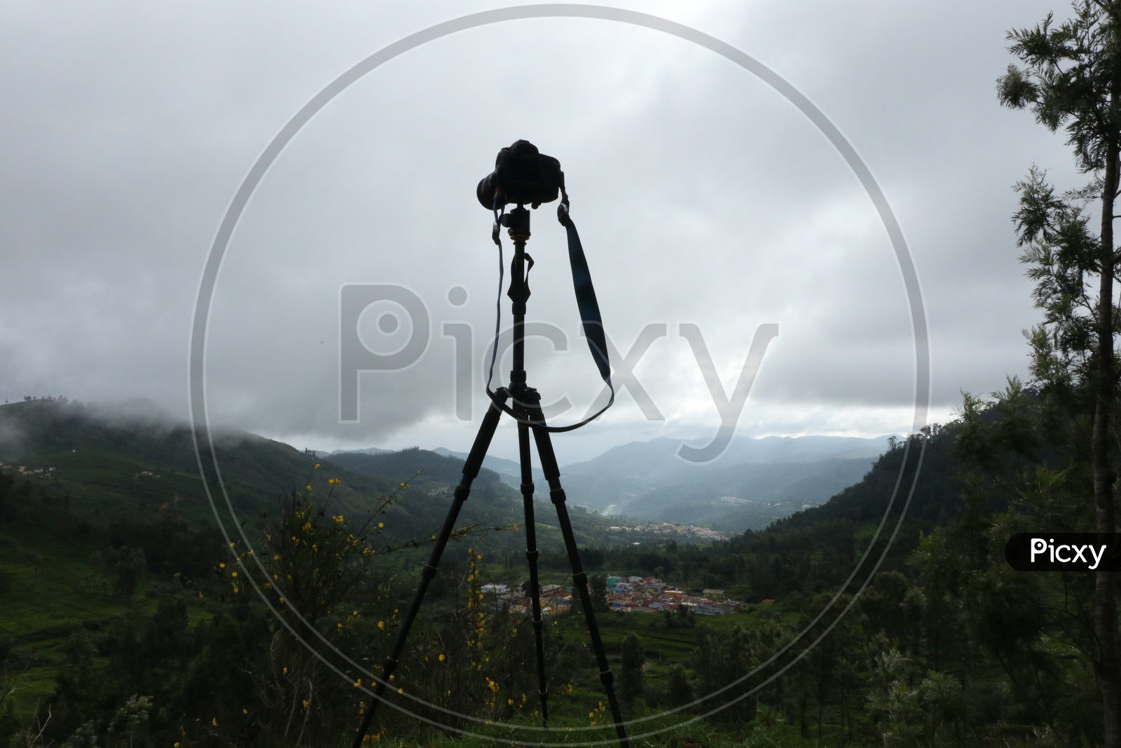A DSLR Camera Mounted to a Tripod on a hill Top
