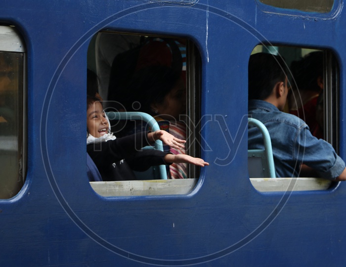 A child Putting His hands Out From Train Window and Smiling In a  Ooty Train