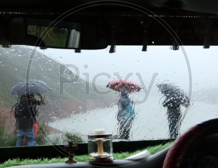 A Tourists Under Umbrella on a Rainy day watching River Valley From a Hill top