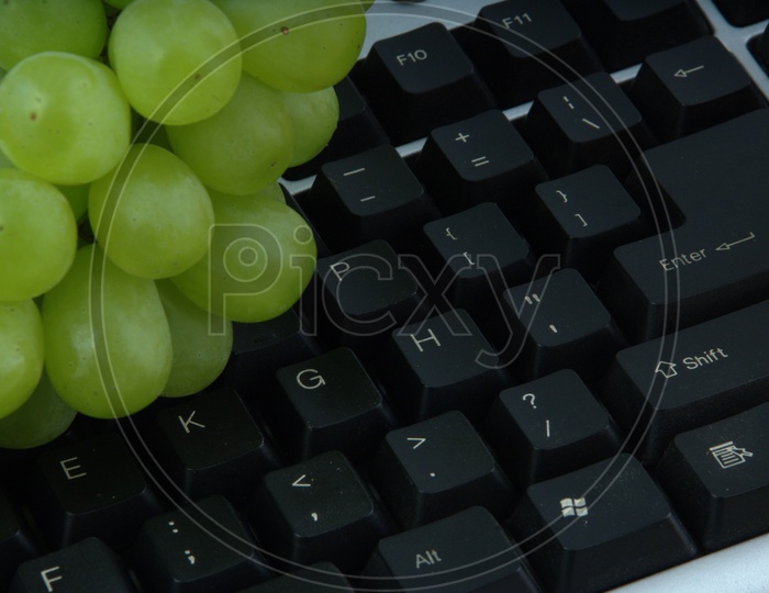 photograph of grapes on a  computer keyboard