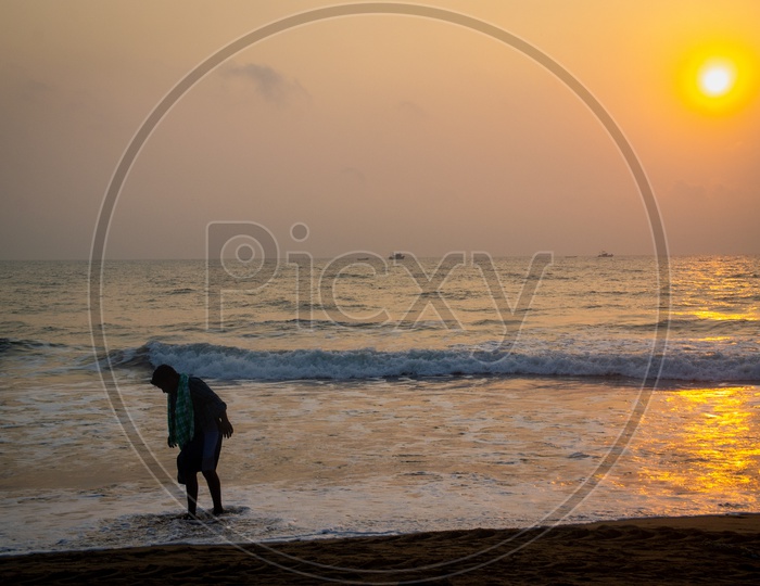 Man bathing at a beach during sunrise