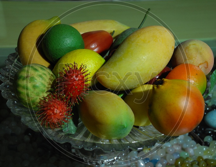 Photograph of artificial fruits in a glass bowl